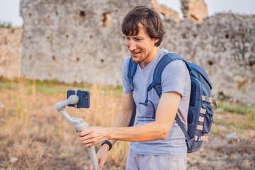 Man tourist explores Aspendos Ancient City. Aspendos acropolis city ruins, cisterns, aqueducts and...
