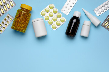 Different pills and bottles of medicines on blue background