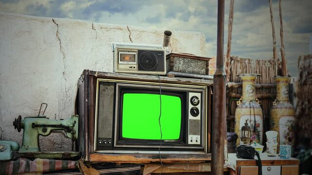 Old TV Green Screen Outside Vintage Devices Zoom In Television. Green screen vintage television and old devices on the exterior of a house, cloudy sky. Zoom in