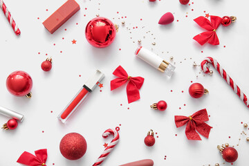 Composition with lipsticks and red Christmas decor on white background