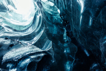 Majestic blue ice formations inside cave glowing covered in frost, transparent icy blocks in vatnajokull glacier crevasse. Glacial iceberg rocks forming natural winter setting in iceland.