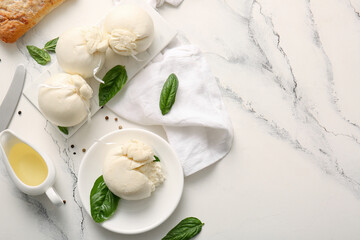 Plate and board of tasty Burrata cheese with basil on white background