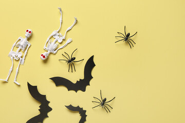 Composition with skeletons, paper bats and spiders for Halloween celebration on beige background
