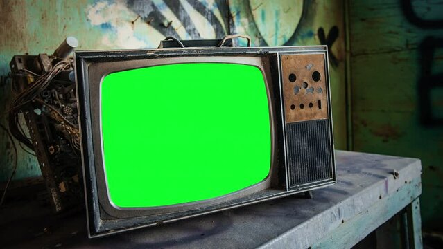 Old Broken TV Green Screen Interference Zoom In Retro Television. Broken vintage television green screen abandoned on a derelict place, zoom in TV.