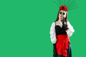 Thoughtful young woman dressed for Halloween on green background