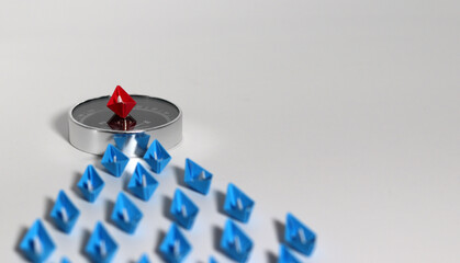 Blue paper boats along red boats on compasses. Conceptual images for business success.
