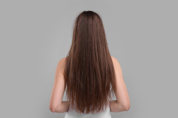 Woman with damaged hair on light grey background, back view - obrazy, fototapety, plakaty