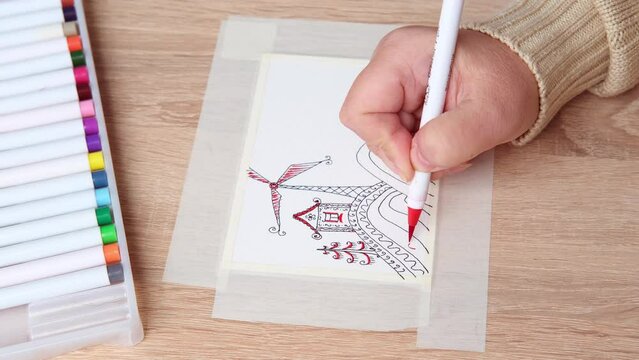 female artist's hand draws with colored paints, blue sky with clouds, background, abstract spots spread on paper, watercolor painting, art therapy drawing for relaxation, mental health supportive care