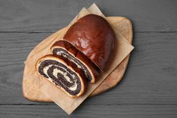 Cut poppy seed roll on grey wooden table, top view. Tasty cake