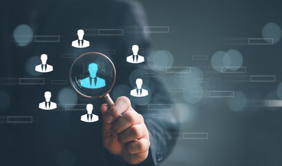 Naklejka premium Human Resource Management HRM concept. Businessman holding magnifier for searching to human icons for human development and recruitment concept.