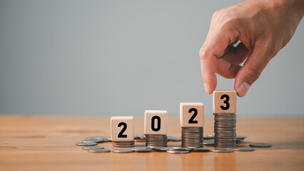 New years 2023 start up investment new business and finance, row of coins with hand putting number...