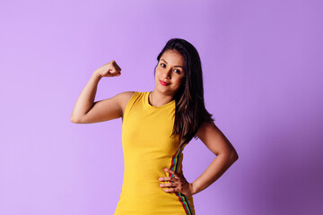 Young latin american woman showing arms muscles, power girl concept.