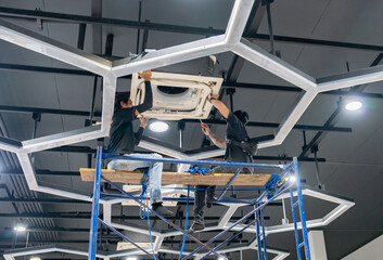 Electrician repairing air conditioner ceiling type