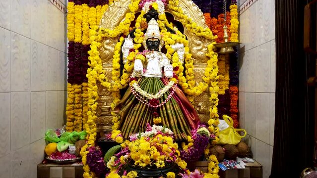 A Stunning view of Goddess Lakshmi or Parvathi stone sculpture decorated with colorful flowers during Diwali and Maha Shivrathri religious festival celebrated across India,