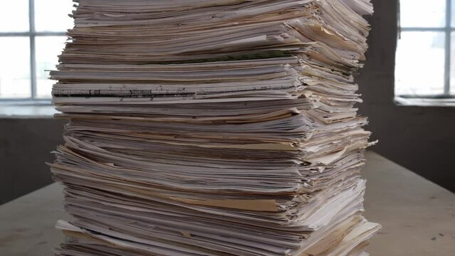 Stack overload document report paper in the office, bureaucracy, paper used business concept. Printed fliers