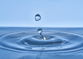 Group of water droplets fall and bounce on a water surface