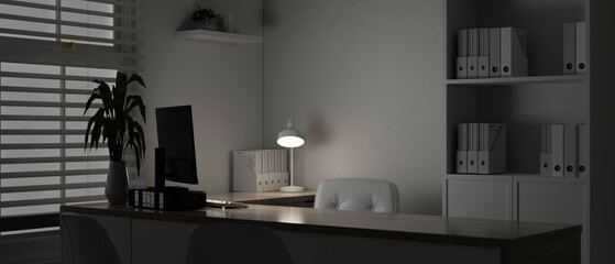 A modern white doctor's office or private office at night with a computer on a table.