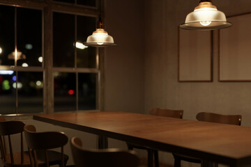 Beautiful vintage wooden dining table with chairs in a minimalist Scandinavian dining room at night.