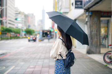 Naklejka premium Woman hold with black umbrella at Taipei city