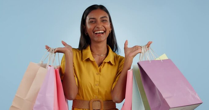Happy woman, shopping bags and discount sale for payment, purchase or buying against a studio background. Portrait of excited female person or shopper smile for deal, spree or retail promotion