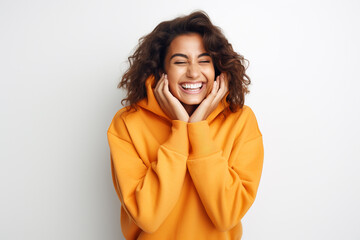 Happy smiling fashionable woman wearing orange color hoodie posing on white background