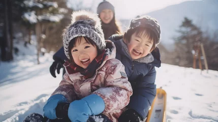 Fotobehang ソリで雪の上をすべる子どもたち © Hanako ITO