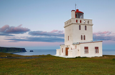 Dyrhólaey lighthouse, located near Vik and on the south central coast of Iceland, at sunset
