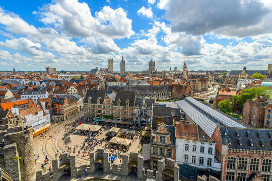 View from the top of the medieval Gravensteen Castle overlooking the old town and St. Veerleplein market square with the church towers and belfry rising above Ghent, Belgium.
