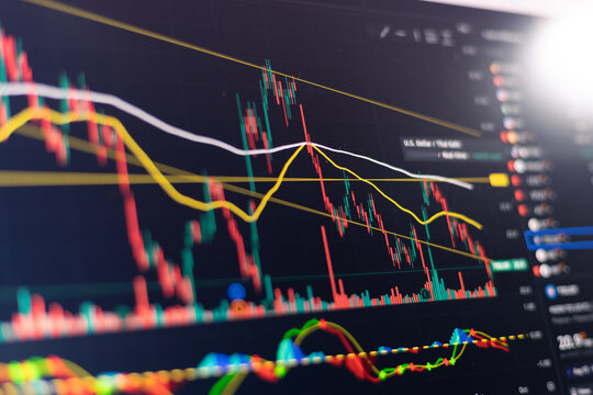 An Investor analysis the stock market exchange from the candlestick graph. Trader at home office trading on computer and using mobile phone. Financial and broker agent investment concept.