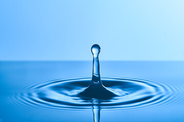 Group of water droplets fall and bounce on a water surface