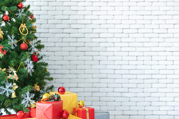 Christmas concept theme background and texture with grey wall background and right copy space. Christmas tree decorated by cute Christmas ornament as color glass ball. Gift boxes near Christmas tree. - 653545900