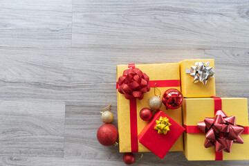 Beautiful colorful Christmas gifts boxes or presents with golden and red color with Christmas baubles as glass ball model on wooden background with copy space. Overhead flat lay view. New year concept - 653545968