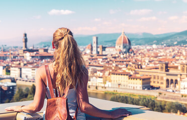 Rear view of female tourist traveling in Italy- Florence city landscape and Duomo