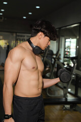 Fototapeta na wymiar Closeup Asian handsome man with perfect body playing weight training at fitness center.