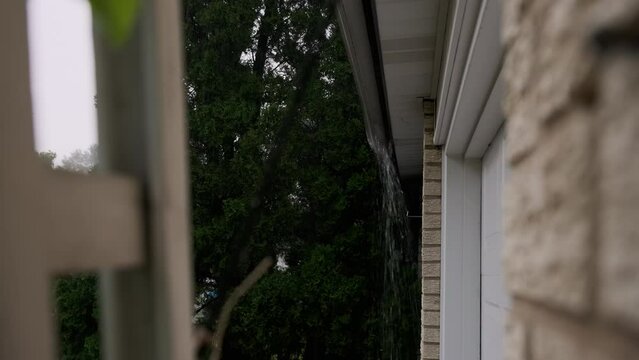 Heavy Rain storm Hitting House Roof and Rain Gutter During Thunderstorm. Close up