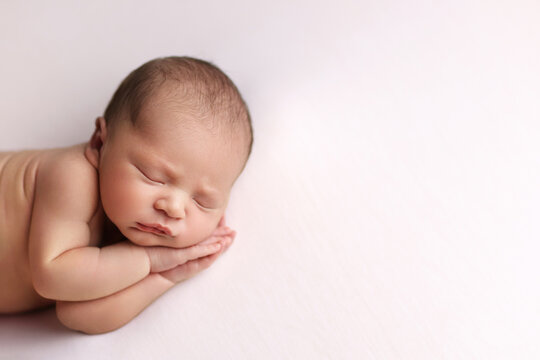 Newborn baby on a white background.
Photoshoot for the newborn. A portrait of a beautiful sleeping newborn baby.