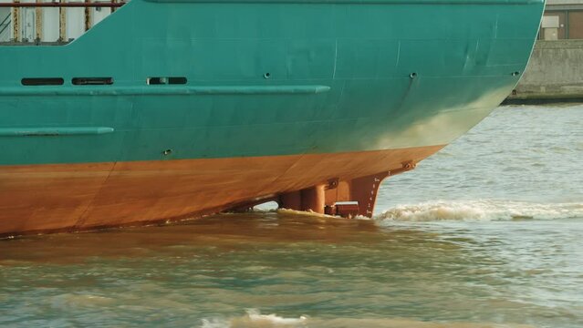 Ship propeller creating prop wash underwater of massive container ship