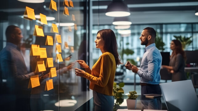 Group Of Creative Marketing Experts During Planning Work In Modern Office, Making Plans And Projects With Post Stickers On Glass Partition.