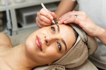 Female client having eyebrows treatment in a salon