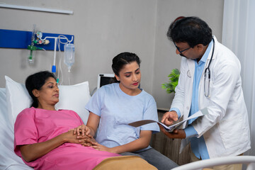 Confident doctor explaining Patients health report to daughter at hospital ward - concept of Family Support, Medical Discussion and Healthcare Update
