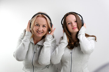 Mother and daughter listening to music on white background. High quality photo