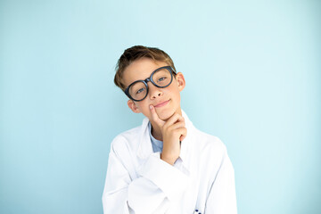 cool young male scientist with white coat and thick black glasses in front of blue background