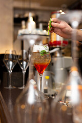 
The secret to making an Aperol spritz. Cool alcoholic drink. Popular cocktail. Light alcohol. quenching thirst. Bartender preparing a cocktail on the bar counter