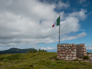 Italian flag at Canfedin view. Summer meadow close to peak of Gazza mountain - 653587556