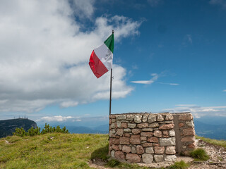Italian flag at Canfedin view. Summer meadow close to peak of Gazza mountain - 653587565