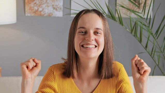 Happy woman rejoicing in her success, raised her hands in triumph, screaming with face filled with happiness and satisfaction ecstatic and thrilled girl celebrating success with resounding hurray