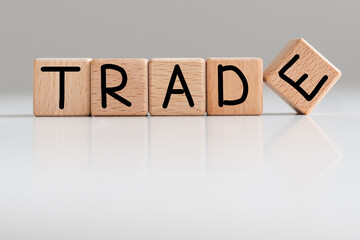 Word TRADE is made of wooden building blocks lying on the table and on a light background. Concept.