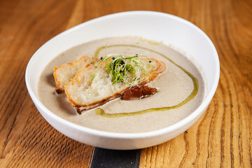 restaurant dish on a wooden table, the first course, soup cream, mushroom