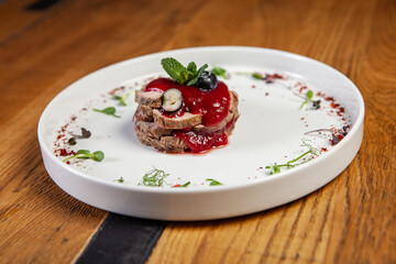 restaurant dish on a wooden table, veal, barbecue sauce