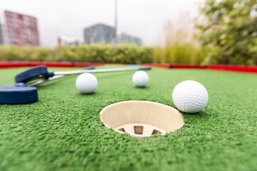 Golf stick and ball on green grass close up.